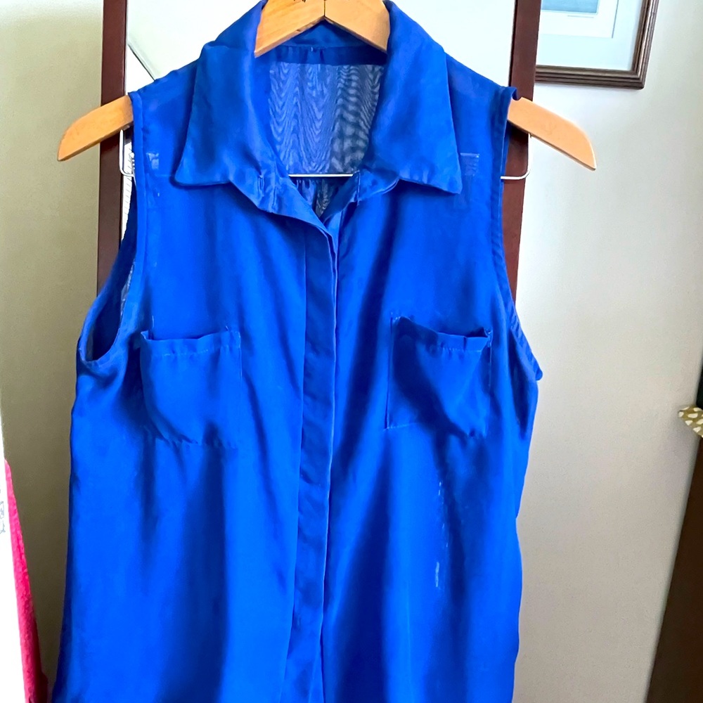 No labels, but 100 percent polyester. Similar to Fuschia sleeveless shirt.